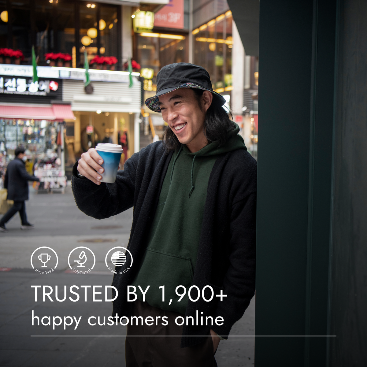 Man holding a coffee cup in an urban setting with text about customer trust.