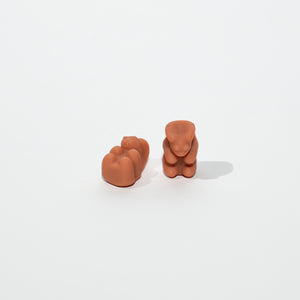 Two terracotta-colored gummybears on a white background