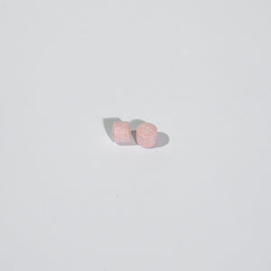 Pair of pink tablets on a light gray background