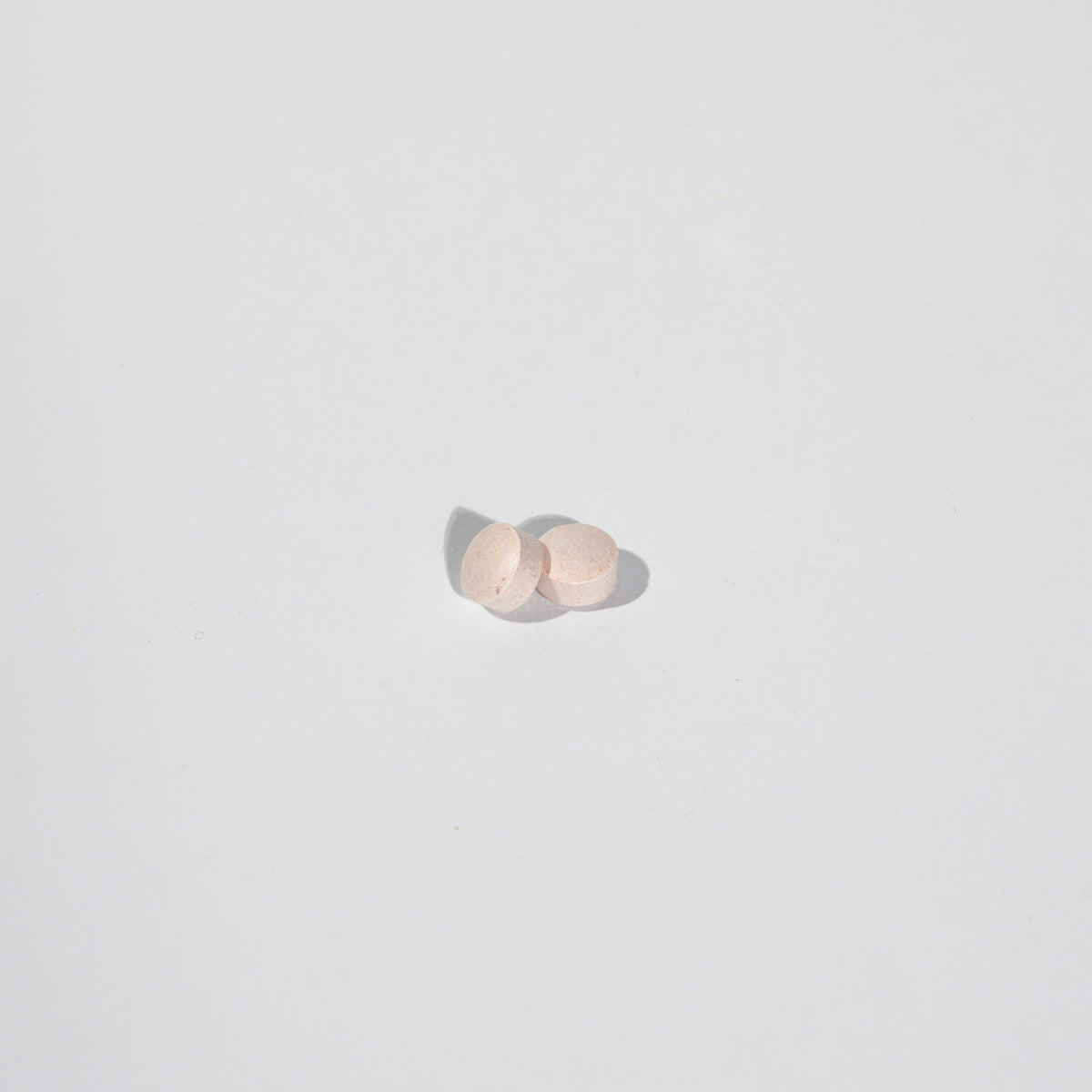 Two small round objects on a light gray background