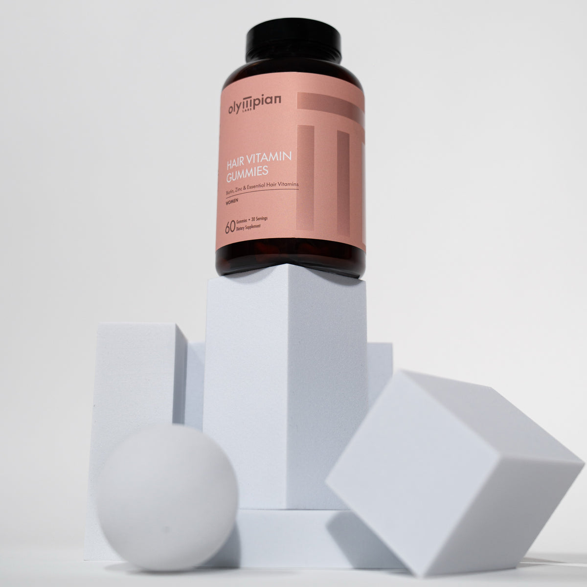 Supplement bottle with pink label on a white geometric background
