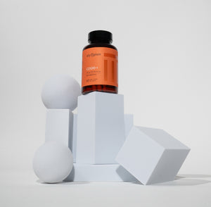 Bottle of a supplement on a geometric white surface with a light gray background