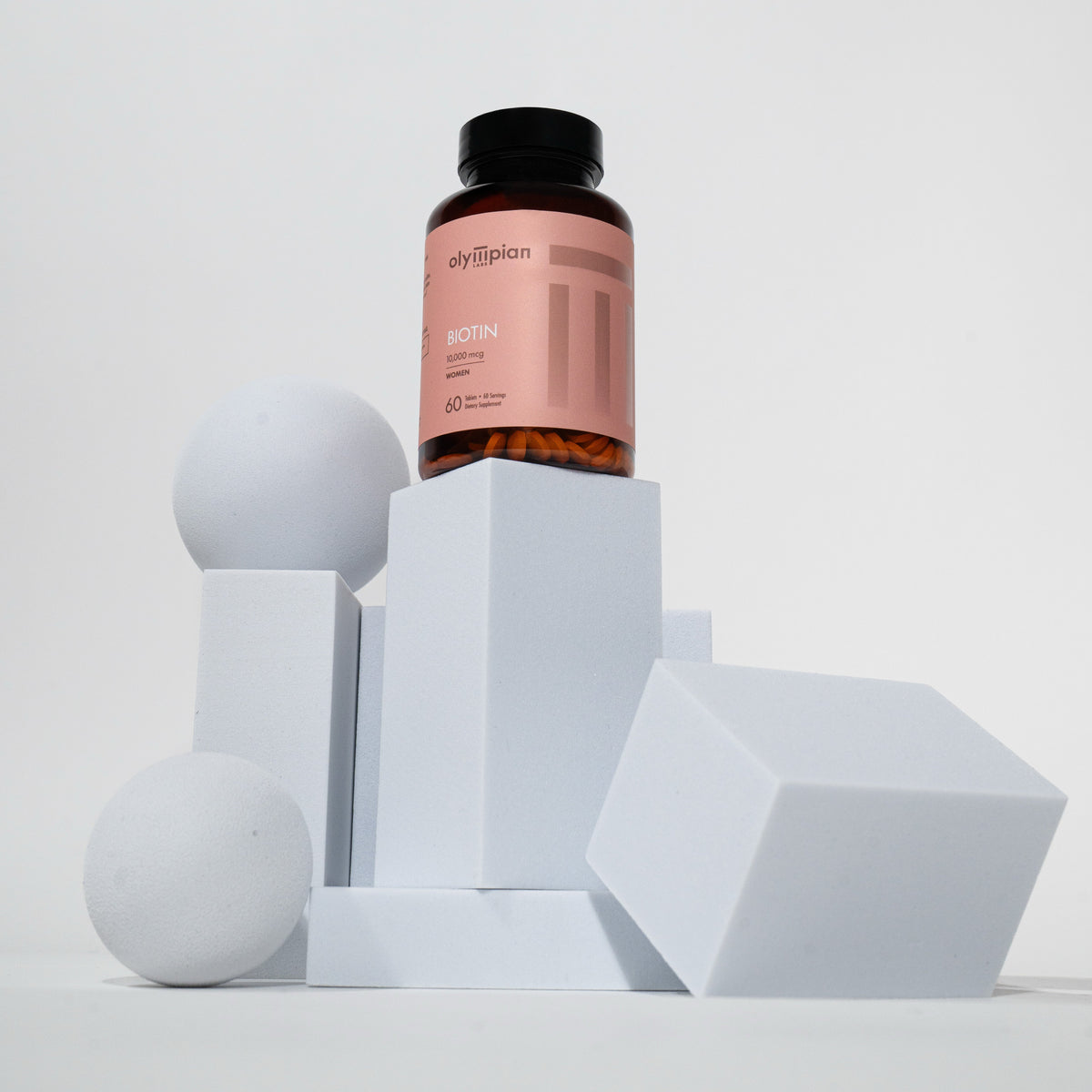 Supplement bottle with pink label on geometric white shapes against a light gray background
