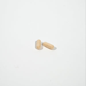 two beige capsules on a white background