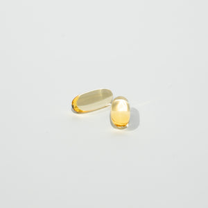 Two yellow capsules on a light gray background