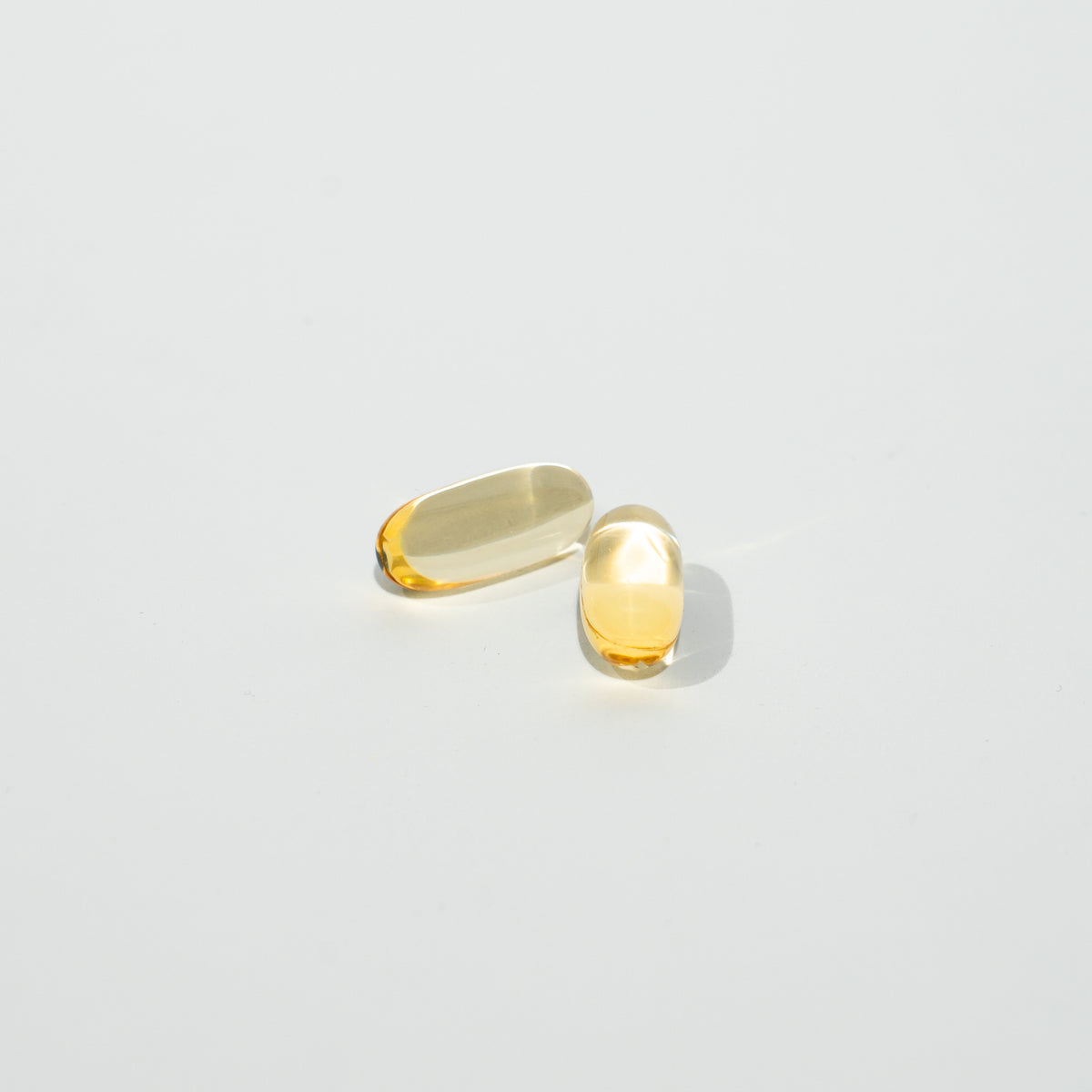 Two yellow capsules on a light gray background