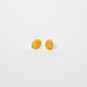 Pair of yellow softgels on a white background