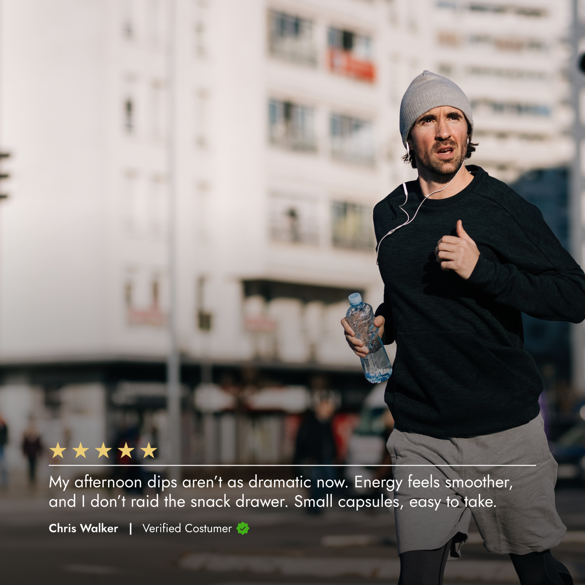 Man running outdoors with a water bottle, wearing a black jacket and gray beanie.
