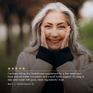Woman with gray hair smiling outdoors, wearing a beige coat and black sweater.