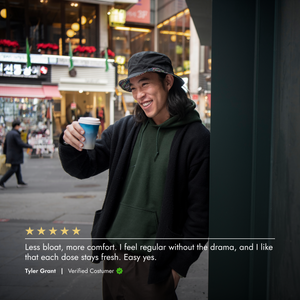 Person holding a coffee cup on a city street with a five-star rating and review text overlay.