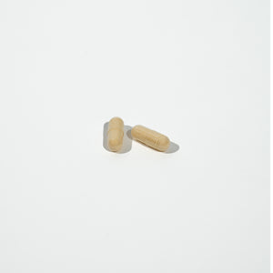 Two beige pills on a white background