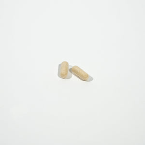 Two beige pills on a white background