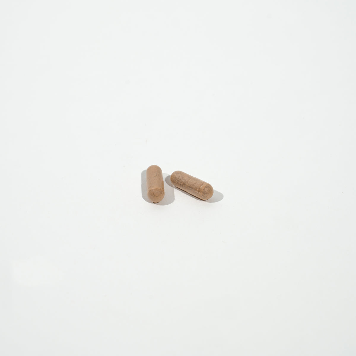 Two wooden pills on a white background