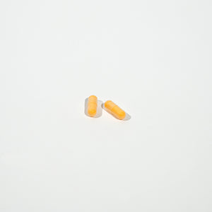 Two yellow pills on a white background