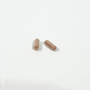 Two brown capsules on a white background