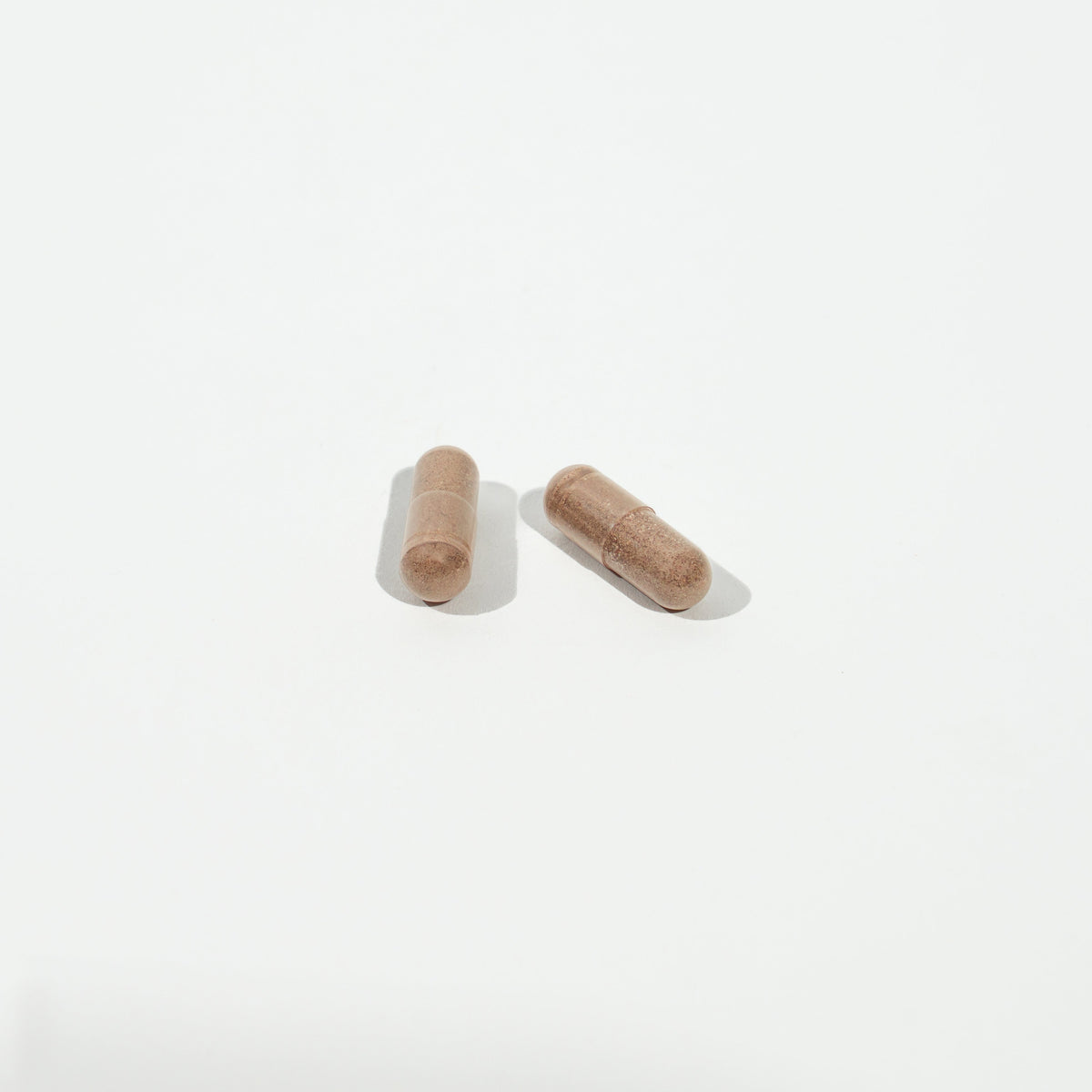 Two wooden capsules on a white background