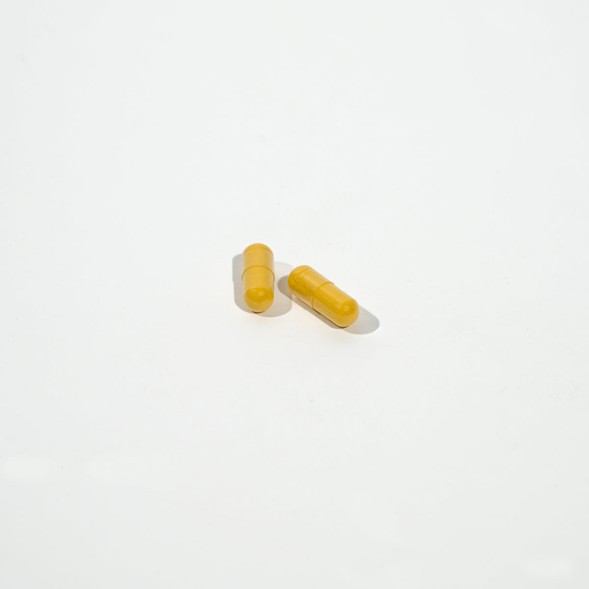Two yellow capsules on a white background