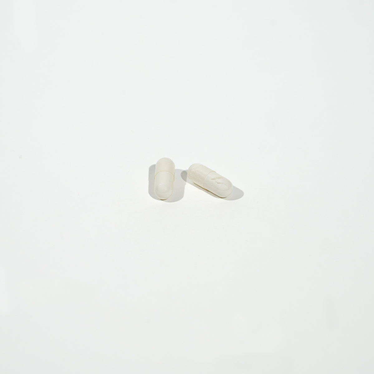 Pair of white cufflinks on a light gray background