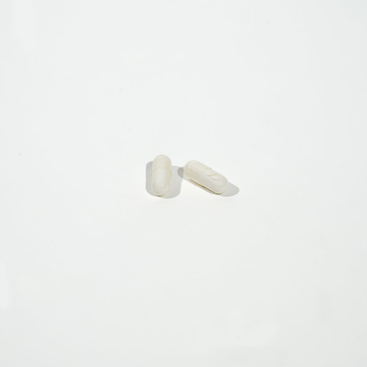 White capsules on a light gray background