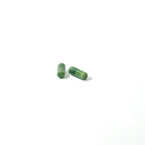 Two green capsules on a white background